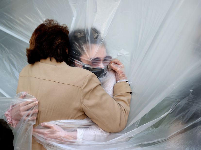A woman hugs her grandmother through a plastic sheet in New York, in May 2020.