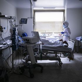 Una enfermera atiende a un paciente en estado grave en una de las habitaciones de la UCI del Gregorio Marañón. El paciente le tumban hacia abajo para disminuir la presión sobre los pulmones y facilitar la respiración. 