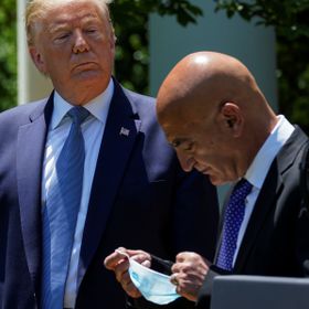 U.S. President Donald Trump looks on as former GlaxoSmithKline pharmaceutical executive Moncef Slaoui, who will serve as chief adviser on the effort to find a vaccine for the coronavirus disease (COVID-19) pandemic, removes his face mask  during a coronavirus response event in the Rose Garden at the White House in Washington, U.S., May 15, 2020. REUTERS/Kevin Lamarque - RC25PG9U9XJO