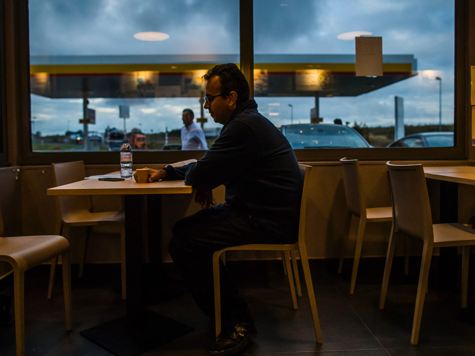 Lázaro toma un cafe en una estación de servicio en Francia.