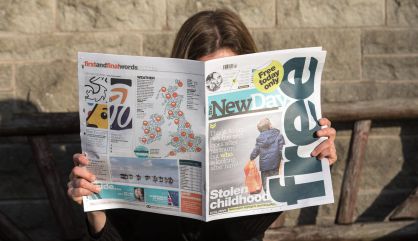 Una mujer lee el periódico 'The New Day', en Bristol.