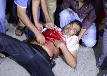 Un hombre herido es atendido cerca del restaurante atacado.  