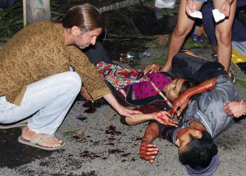 Un herido es socorrido por varias personas tras la explosi&oacute;n regsitrada en Hua Hin, en Tailandia. 