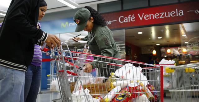 Una soldado revisa un carro.
