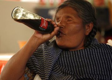 Una ind&iacute;gena mazahua bebe coca-cola