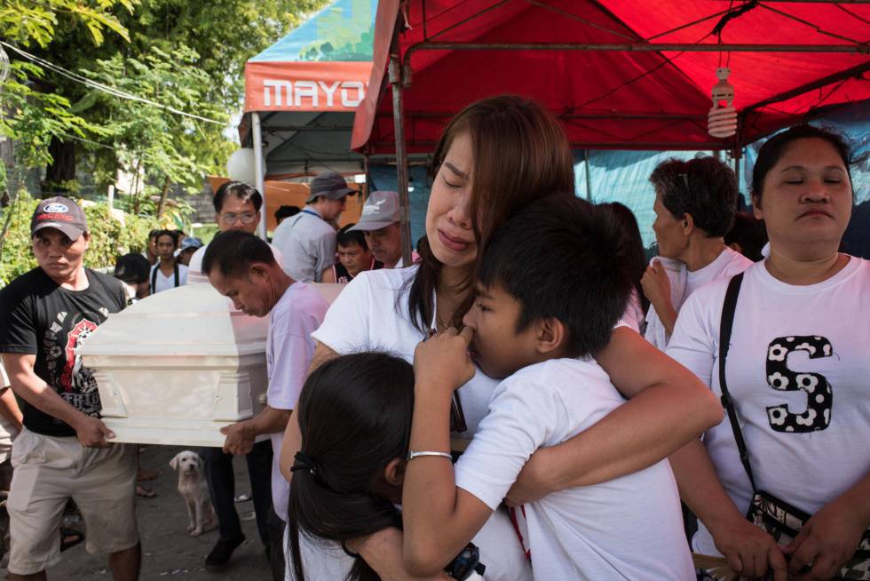 La esposa y los hijos de Alex Hongco lloran mientras sus parientes llevan el ataúd con su cuerto. Hongco y tres hombres más fueron asesinados cuando la policía irrumpió en una casa de Manila en una redada antidroga en diciembre pasado.