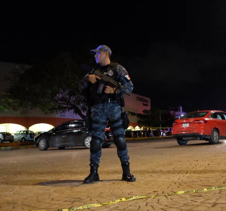 Un policía vigila las calles de Cancún tras el tiroteo del jueves