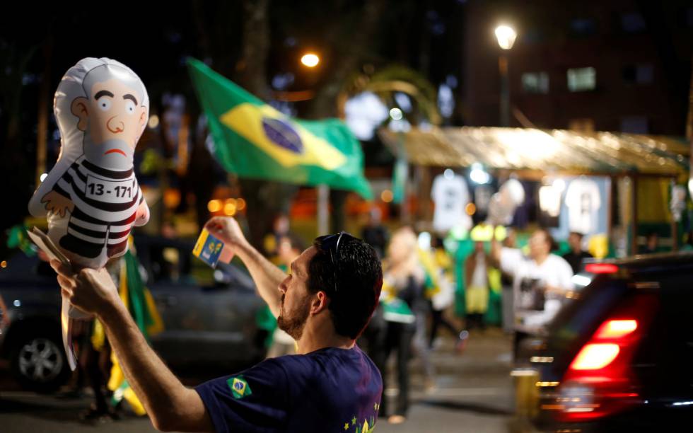 Un hombre sostiene un globo del expresidente Lula da Silva vestido como un reo en una manifestación en Curitiba (Paraná)