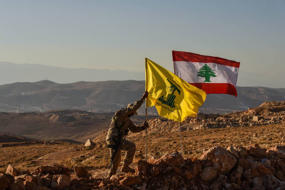 Un miliciano de Hezbolá planta las banderas libanesa y de la milicia tras expulsar a Al Nusra de los arreales de la localidad libanesa de Arsal