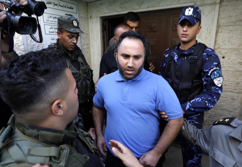 Agentes palestinos custodian al activista pacifista Issa Amro en Hebrón.