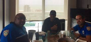 Andrés Asión come con dos policías en su casa de Miami.