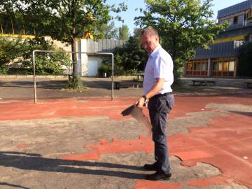 Matthew George, diretor da escola Paul-Hindemith de Frankfurt, mostra o mau estado do chão do pátio.
