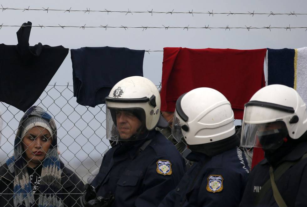 Una mujer mira a policías griegos en la frontera con Macedonia, en una foto de archivo.rn 
