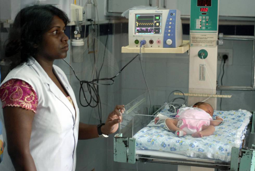 Una enfermera india con un bébé nacido a través de la maternidad subrogada en un hospital de Jaipur, este agosto.