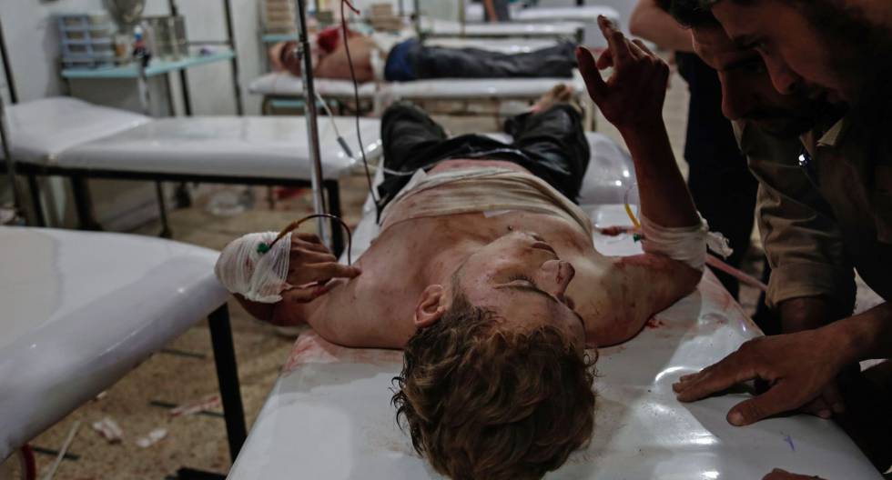 Dos hombres tratan de comunicarse con un herido en un hospital improvisado de Duma, a las afueras de Damasco, el pasado 26 de septiembre.rn 