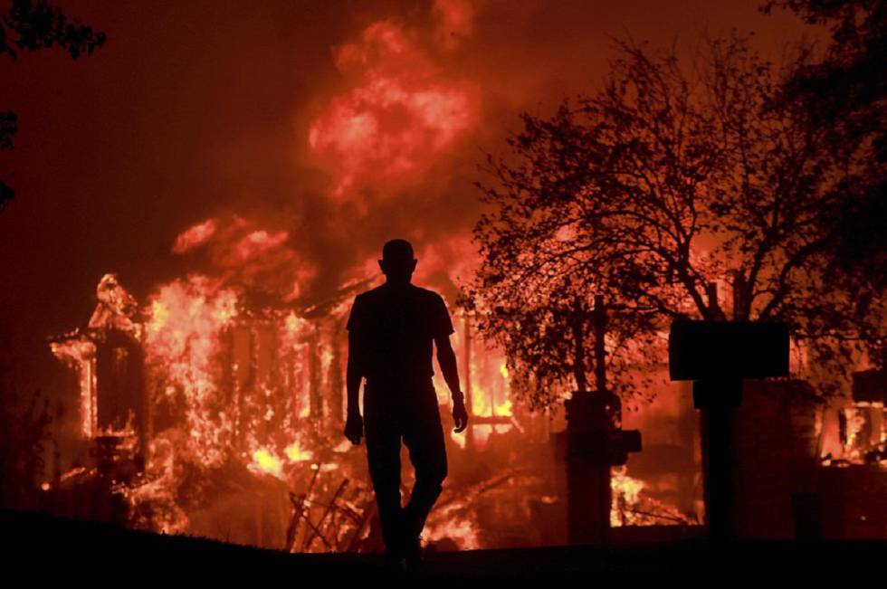 Jim Stites observa como se quema parte de su barrio en Fountaingrove, California.