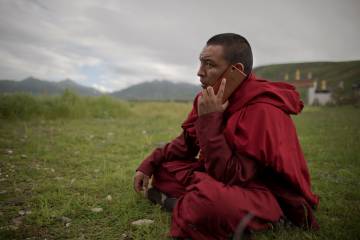 Un tibetano budista habla por teléfono, en Yushu County