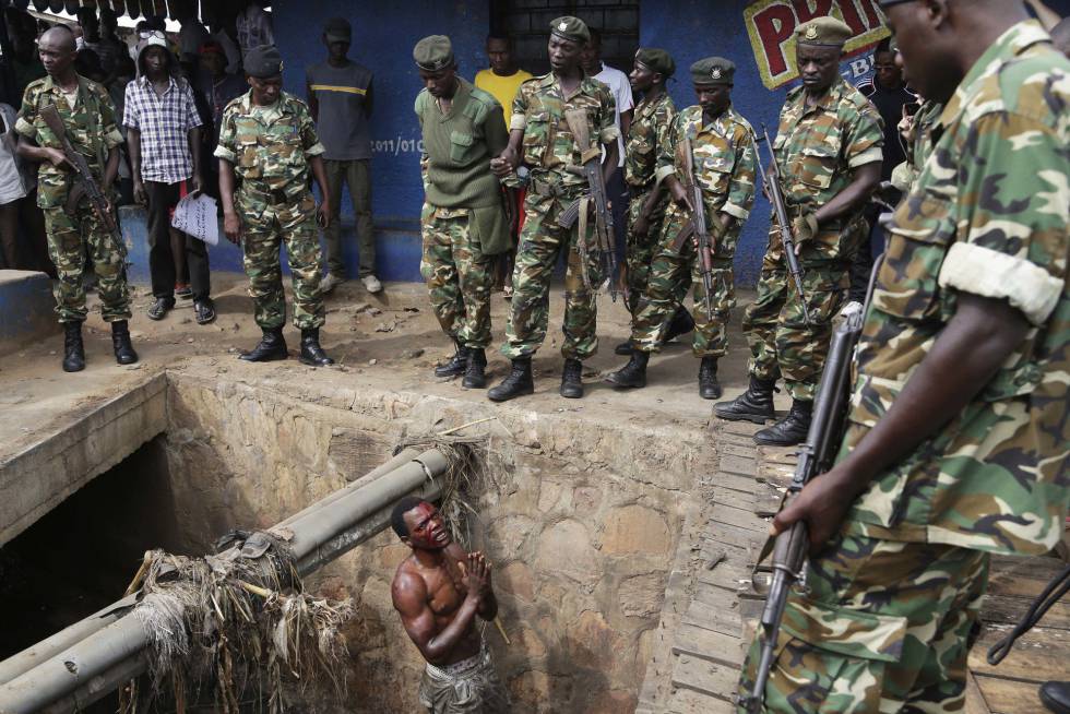 Un presunto miembro de la milicia juvenil Imbonerakure del partido gobernante, suplica a los soldados que lo protejan de una multitud de manifestantes el pasado mayo en Burundi.