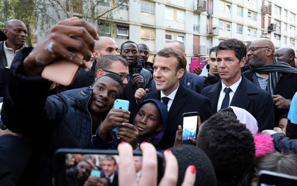 El presidente francés, Emmanuel Macron (c), se fotografía con residentes de Clichy-sous-Bois, a las afueras de Paris, este lunes.