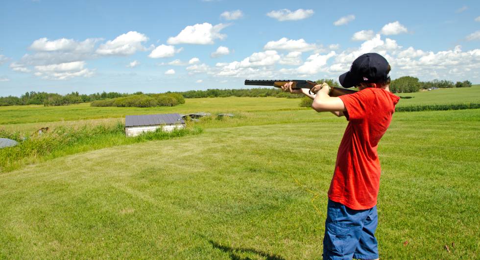 Un niño apuntando con una escopeta.
