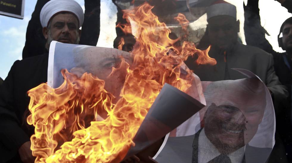 Un grupo de palestinos quema fotos de Netanyahu y Trump, este jueves en Gaza.