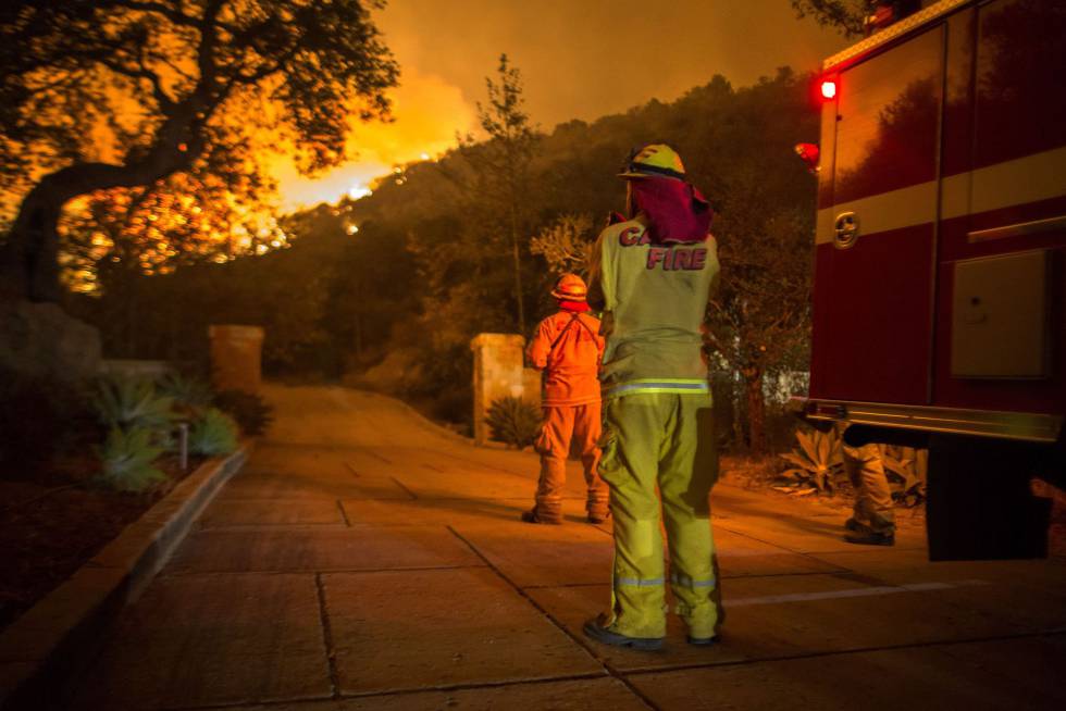 Los bomberos observan el incendio Thomas acrecarse a las casas de Montecito, California, en la noche del martes.