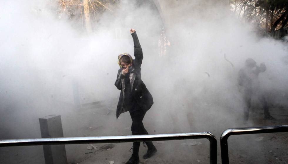 Una joven levanta el puño durante los choques entre manifestantes y policía en la Universidad de Teherán.
