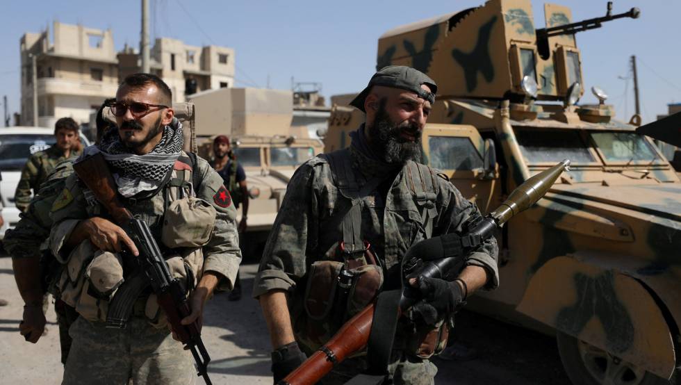 Combatientes de las Fuerzas Democraticas Sirias, junto a un vehiculo militar en Raqa, en el norte de Siria, el pasado mes de octubre.