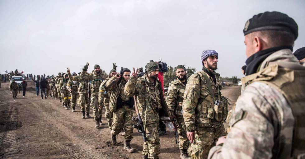 Soldados de la oposición a Bachar el Asad caminan frente a tropas turcas cerca de Hassa el 22 de enero de 2018, para combatir a los kurdos de Siria.