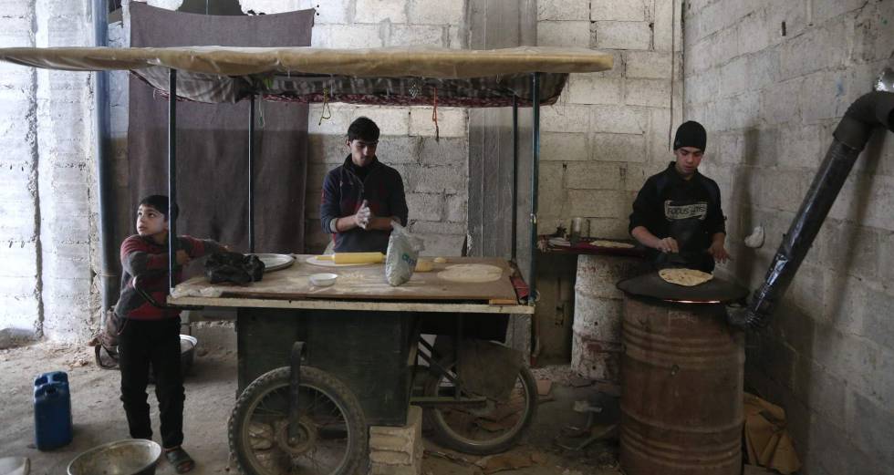 Un grupo de niños sirios prepara pan, este martes en Hamouria (Guta Oriental).