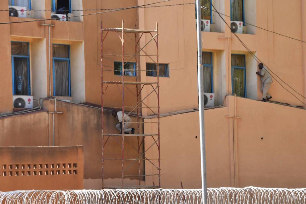 Dos hombres tratan de salir de la sede general de las Fuerzas Armadas en la capital de Burkina Faso este viernes.