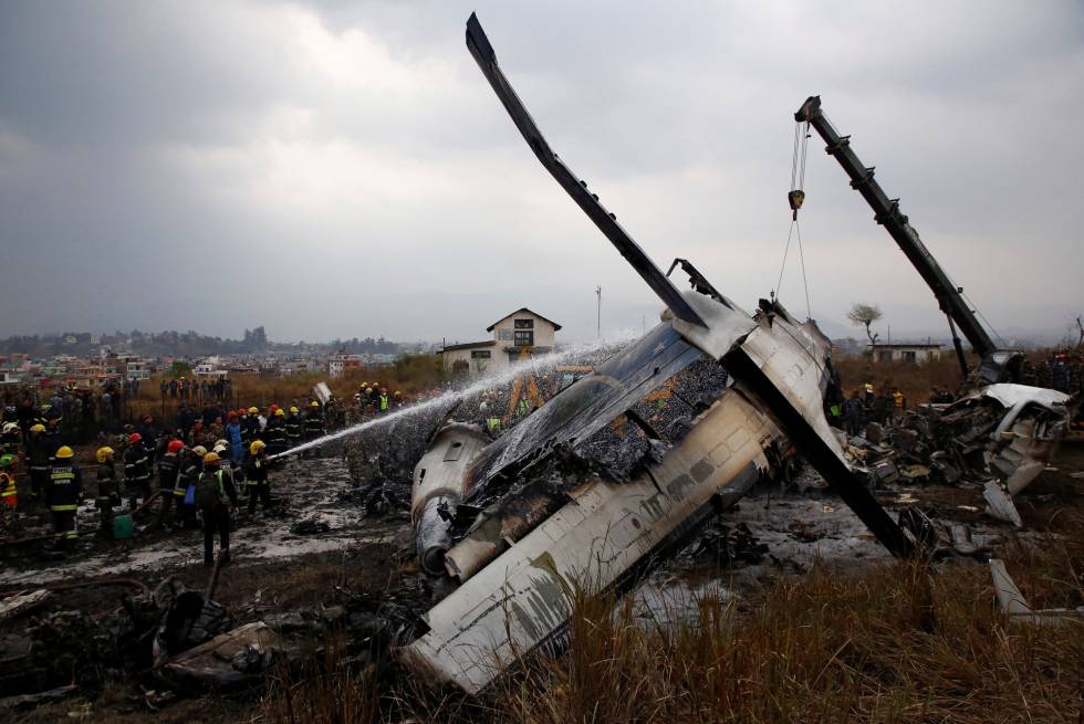 Los bomberos apagan las llamas del avión accidentado en Nepal procedente de Bangladés.