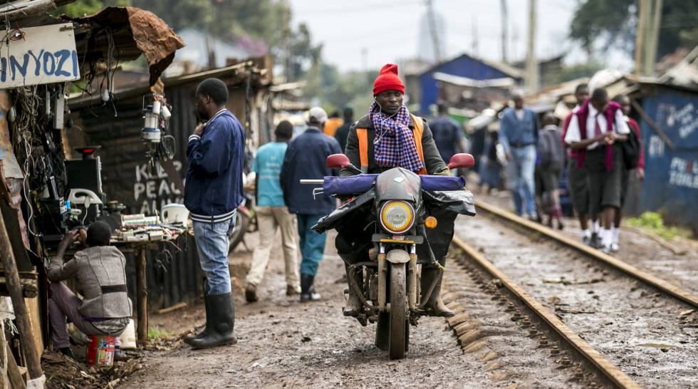 Un hombre conduce una moto junto a las vÃ­as de tren de Kibera, suburbio de Nairobi, la capital de Kenia.