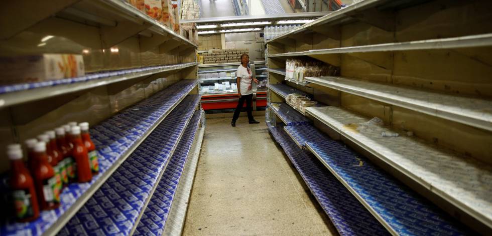 Una mujer ante los estantes casi vacíos de un supermercado en Caracas el viernes.