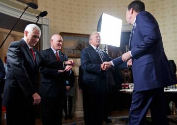 El presidente Donald Trump da la mano al entonces director del FBI, James Comey, en la Casa Blanca.
