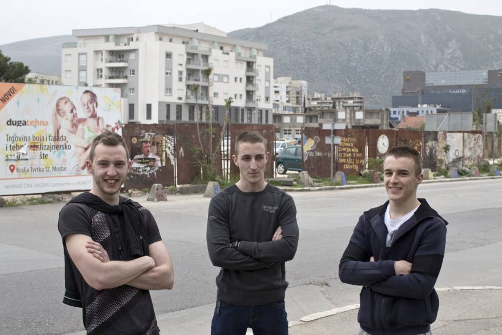 Tres jóvenes bosniocroatas posan en el lugar exacto donde estaba la trinchera de Mostar en la guerra de Bosnia (1992-1995), que hoy en día es la línea que marca la división entre croatas y bosniacos.