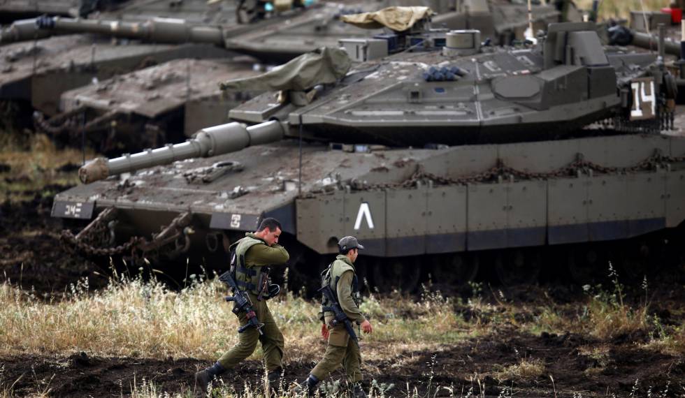 Soldados israelíes junto a los tanques desplegados en la frontera de los Altos del Golán, el martes.