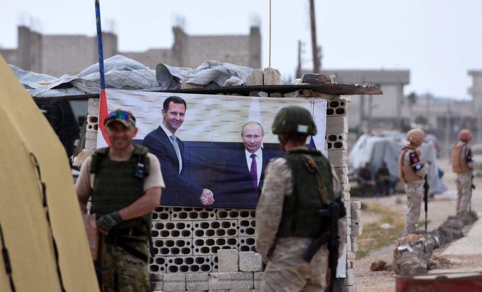 Militares rusos en un 'checkpoint' con un pÃ³ster de El Asad y Putin, en el oeste de Siria.