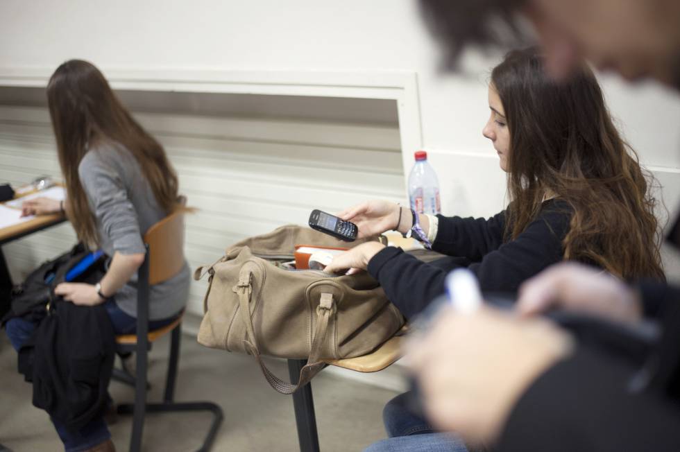 Una joven francesa consulta su móvil en clase.