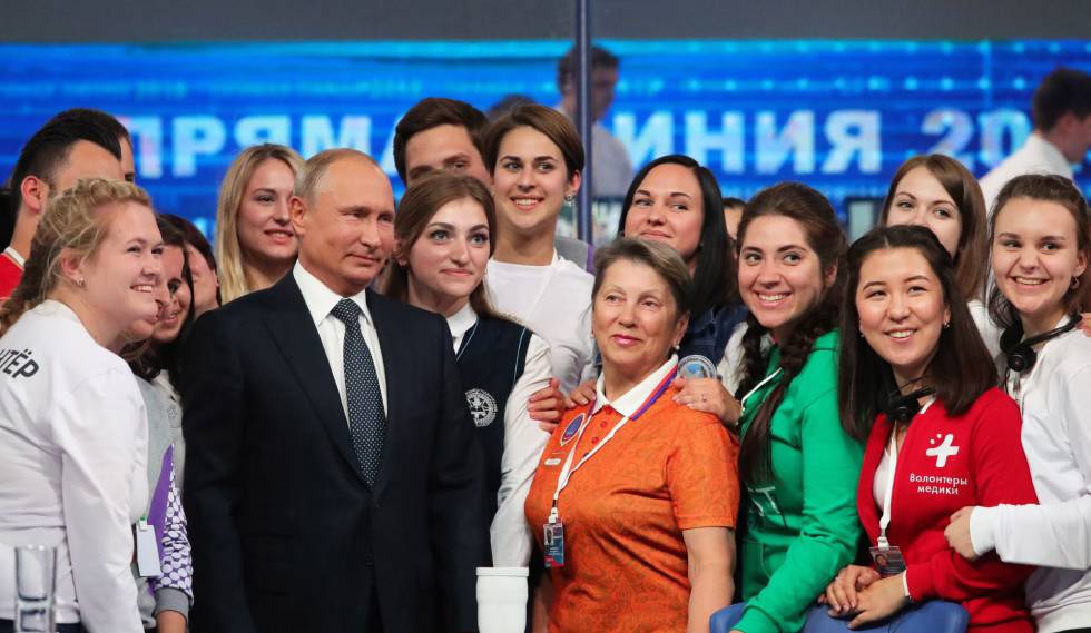 El presidente ruso, VladÃmir Putin, posa con un grupo de voluntarios tras su programa nacional en directo.