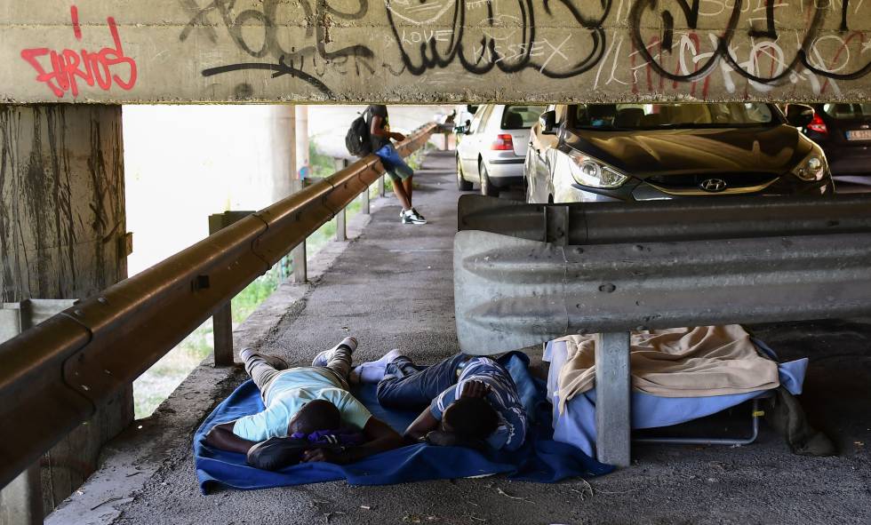 Varios migrantes, este jueves durmiendo bajo un puente en Ventimiglia (Italia).