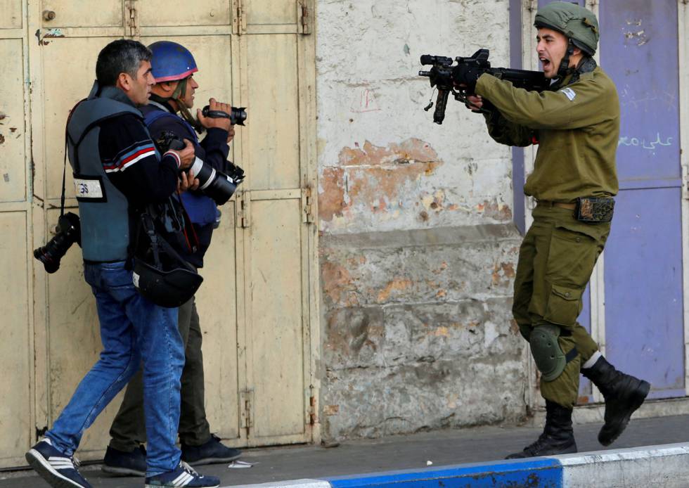 Un soldado israelÃ­ apunta con su arma junto a dos reporteros, el pasado diciembre en HebrÃ³n (Cisjordania).