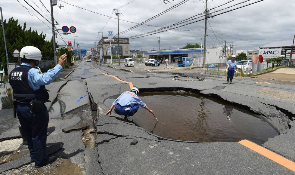 Un policÃa revisa un socavón causado por el terremoto en Takatsuki, al norte de Osaka, este mañana.