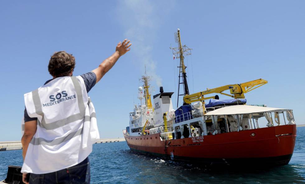 An NGO worker waves to the â€˜Aquariusâ€™ as it leaves Spain.