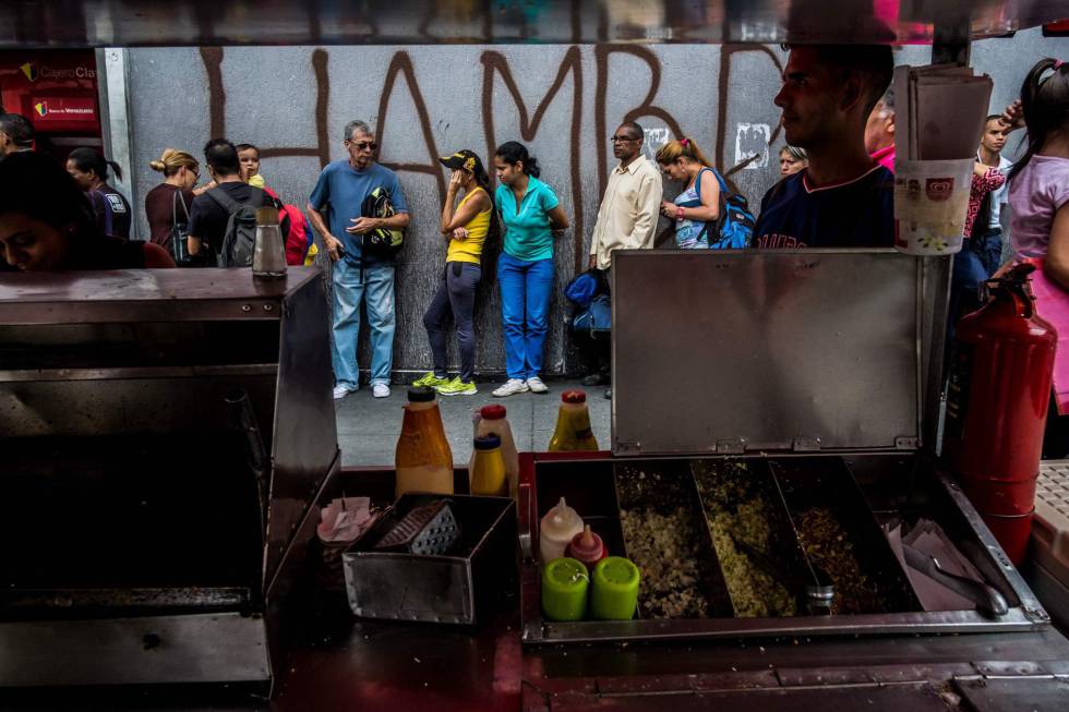 Varias personas hacen cola el pasado lunes para sacar dinero de un cajero de Caracas. 