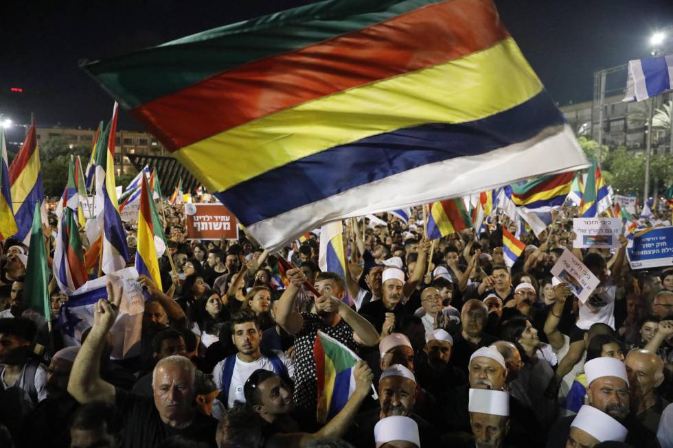 Manifestantes contra la ley del Estado naciÃ³n ondean la bandera drusa en Tel Aviv.