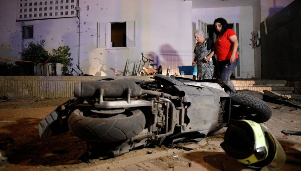 Dos personas en el lugar donde explotó un cohete este miércoles en la ciudad de Sderot, al sur de Israel.