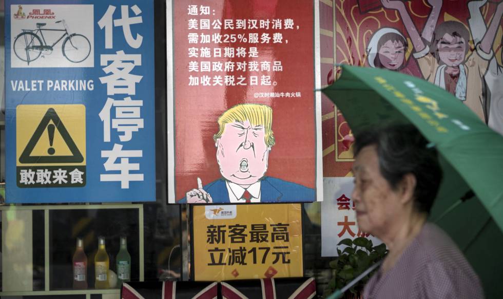 Una mujer pasa junto a un pÃ³ster que caricaturiza a Trump, en Guangzhou.