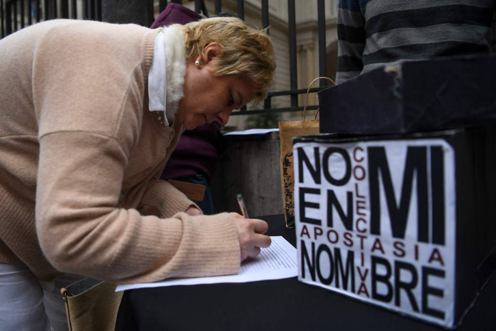 Una mujer completa la peticiÃ³n de apostasÃ­a frente a la Conferencia Episcopal Argentina.