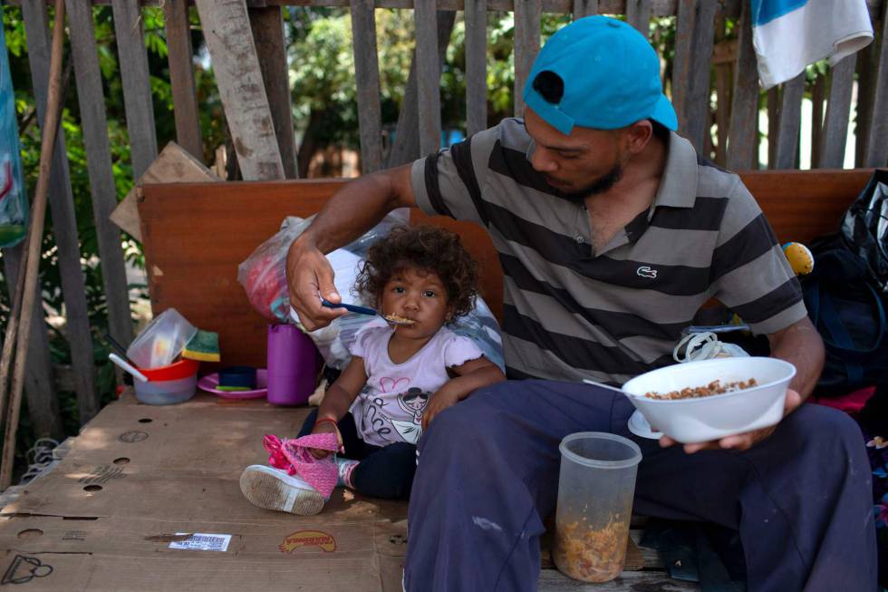 Un venezolano alimenta a su hija en el Estado de Roraima una tarde de agosto de 2018